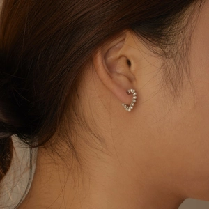 Close-up of elegant C-shaped sterling silver earrings with small white pearls