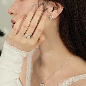 Close-up of sparkling butterfly jewelry set with zircon stones worn by a model