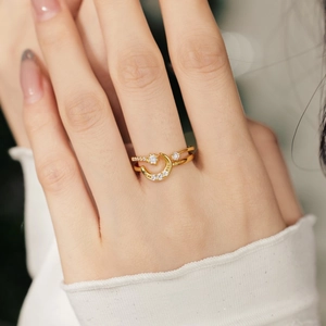 Nahaufnahme eines goldenen Stern- und Mondrings mit Zirkonia-Steinen an der Hand