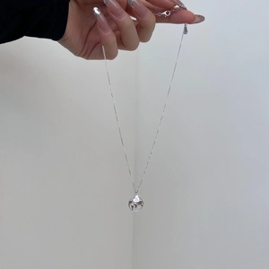 Macro shot of S925 sterling silver globe necklace with Just Go engraved heart pendant