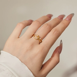 Detailansicht des Goldrings mit Mond und Stern sowie Zirkonia, getragen am Finger eines Modells