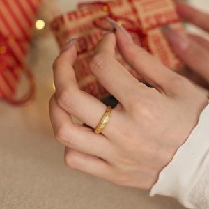 Macro shot of S925 silver gold star ring with zircon being held on a Christmas gift box