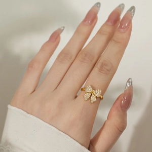 Detailed view of an elegant gold butterfly ring with zircons worn on a finger