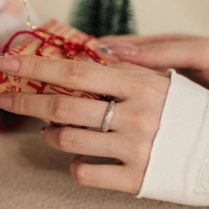 Close-up of S925 silver star ring with matte finish on hand holding a Christmas gift box