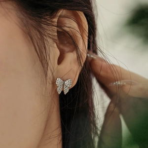 Close-up of S925 sterling silver butterfly earrings with cubic zirconia on female ear