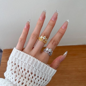 Detail of luxury S925 silver crown rings with zircons on model's hand in gold and silver