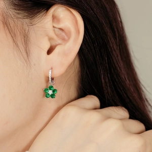 Gros plan de boucles d'oreilles en argent S925 avec pierres vertes sur un mannequin