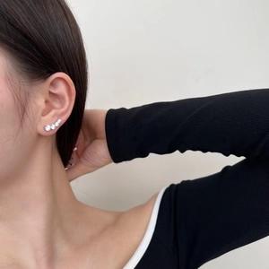 Close-up of curved S925 sterling silver ear crawlers with graduated round zircon stones