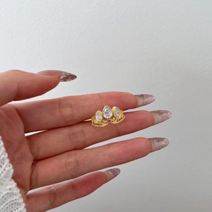 Macro shot of crown ring with pear-cut zircon and pink stones in gold-plated finish