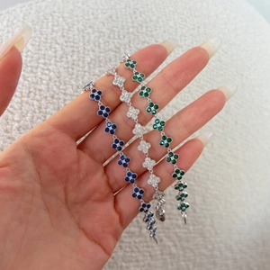 Detailed close-up of S925 silver clover bracelets with blue, green, and clear stones