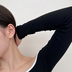 Side view of model wearing a leaf-shaped gold stud earring with sparkling cubic zirconia