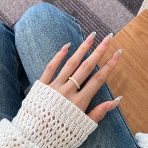 Close-up of a double-row zircon gold eternity ring worn on a finger with casual wear