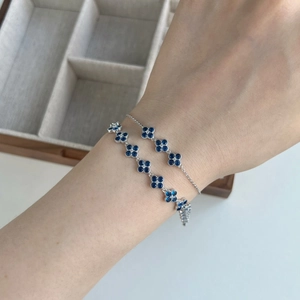 Detailed view of a S925 silver bracelet with blue zircon four-leaf clover charms on wrist