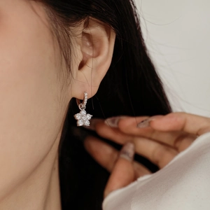 Gros plan de boucles d'oreilles fleur en argent S925 avec zircons sur un modèle