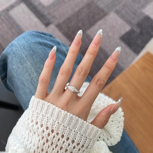 Detail of S925 sterling silver ring with zircon on hand over white sweater background