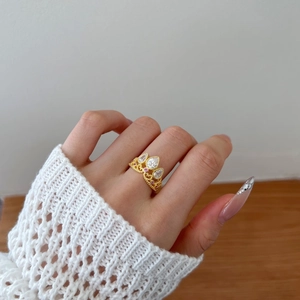 Luxurious gold crown ring with pear-cut crystals and pink zircon on a female hand
