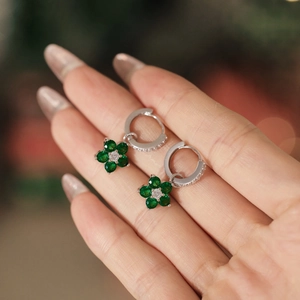 Gros plan des boucles d'oreilles en argent S925 avec pétales verts et pavé de cristaux