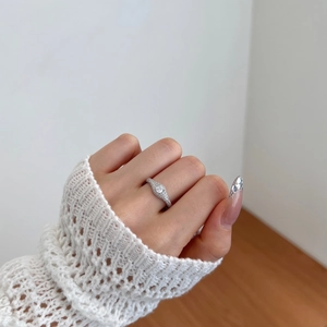 Close-up of S925 sterling silver ring with brilliant round zircon and pave diamond band