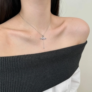 Close-up of S925 silver heart necklace with pink stone and wing pendant on a model