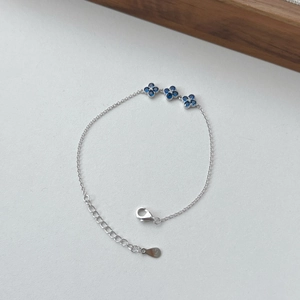Detail of S925 sterling silver clover bracelet with blue stones and lobster clasp closure