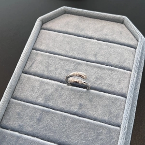 Detailed macro shot of S925 sterling silver snake ring with pavé zircons on blue velvet