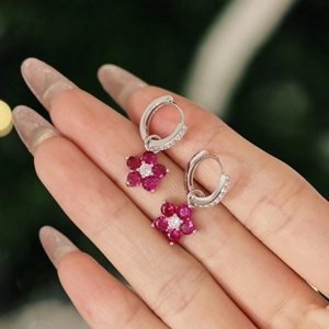 Vue détaillée de boucles d'oreilles fleur en argent avec pétales rouges et cristaux