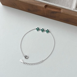 Detail of S925 silver bracelet featuring green clover charms with zircon inlay and clasp