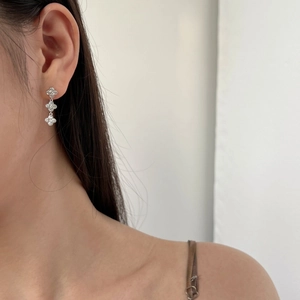 Close-up of S925 sterling silver drop earrings with triple clover zircon inlay