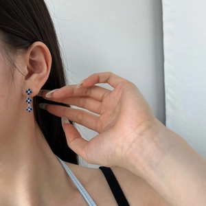 Detail view of S925 sterling silver drop earrings with three-tier blue clover zircon