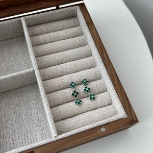 Detailed view of silver S925 earrings with three green clover-shaped zircon stones