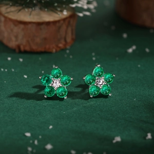 Vue détaillée de boucles d'oreilles fleur avec pétales verts et cristal central brillant