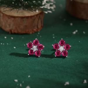 Détail macro de boucles d'oreilles fleur en argent S925 avec zircons rouges et brillants