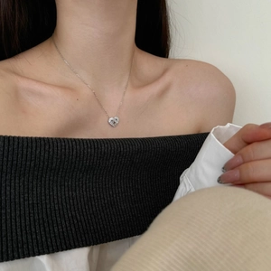 Close-up of S925 sterling silver heart pendant with baguette-cut zircons on a model