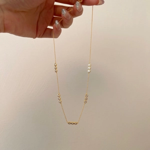 Detail of gold-plated S925 silver necklace featuring bezel-set round cubic zirconia stones