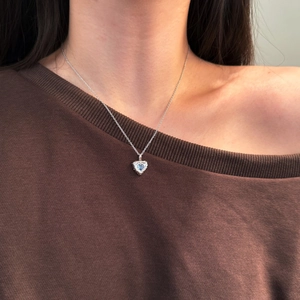 Close-up of S925 silver heart necklace with blue gemstone on model neck