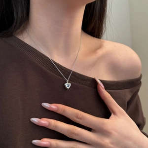 Detail of s925 silver heart necklace with blue gemstone on model neck