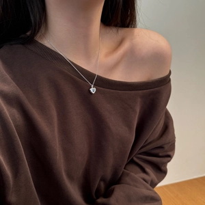 Close-up of S925 sterling silver necklace with light blue heart-shaped gemstone on model