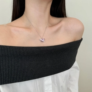 Modella che indossa collana in argento S925 con cuore rosa e design ad anello planetario