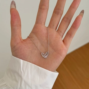 Gros plan détaillé du pendentif cœur double couche avec zircon rose et chaîne en argent s925