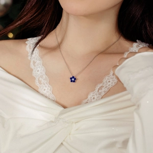 Détail du collier en argent 925 avec pendentif fleur de prunier bleue sur cou de femme