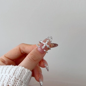 Dettaglio del set di anelli a croce in argento S925 con zirconi scintillanti sulla mano
