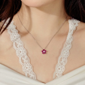 Détail d'un collier en argent S925 avec pierres rouges et motif floral sur le cou