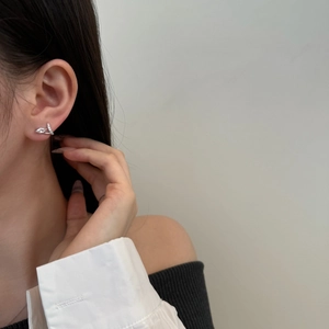 Detail of s925 silver leaf stud earring with marquise zircon on a model's ear