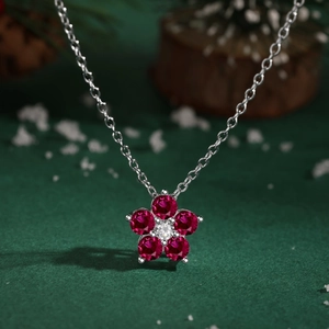 Vue macro du collier fleur de prunier en argent avec gemmes rouges et un zircon central