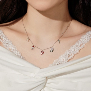Close-up of S925 sterling silver HAPPY necklace with festive Christmas charms on model