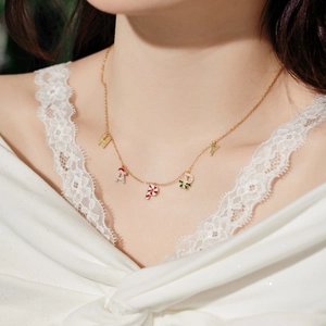 Detail of S925 silver gold necklace with festive HAPPY pendant on a female model