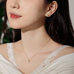 Close-up of elegant gold flower necklace and matching earrings set on a female model