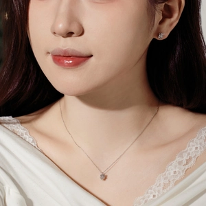 Detail of silver S925 antler bow necklace and stud earrings set worn by a model