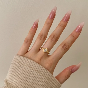 Close-up of a 925 sterling silver gold ring with an oval zircon on a model hand