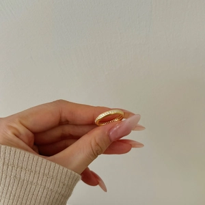 Close-up of elegant gold eternity ring with white zircons on a model hand